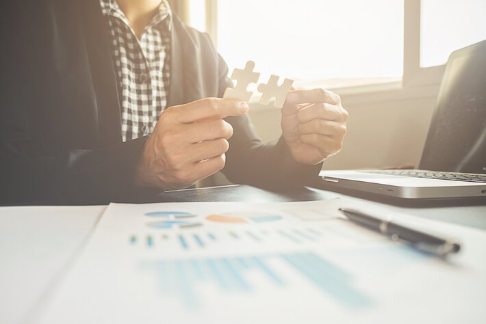 Business man hands connecting jigsaw puzzle. Business solutions, success and strategy concept. Close up photo with selective focus.