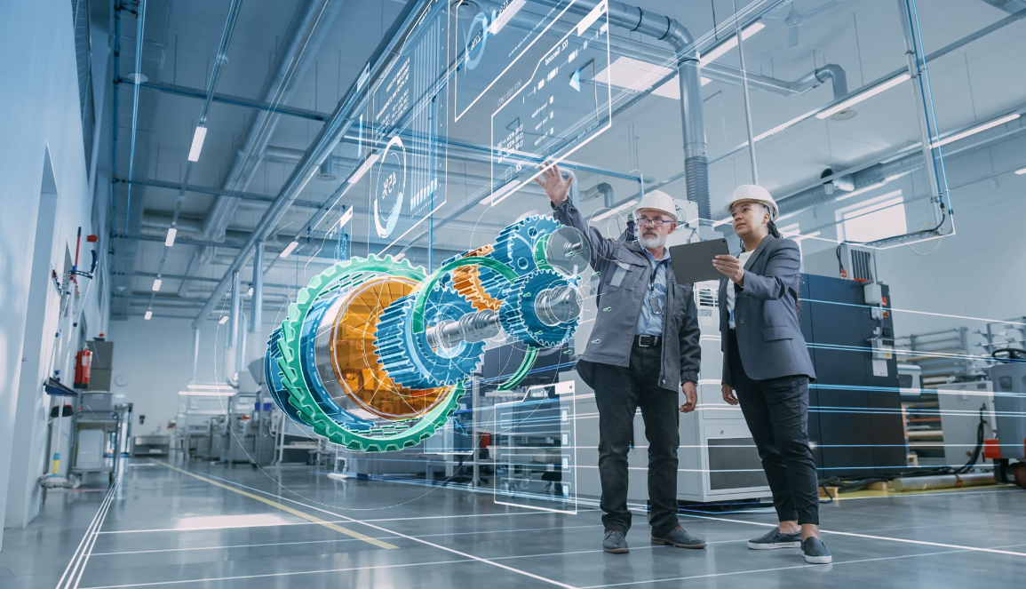 two factory workers pointing at a hologram of a machinery