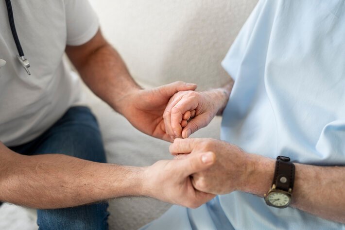 A Doctor holding hands of a patient